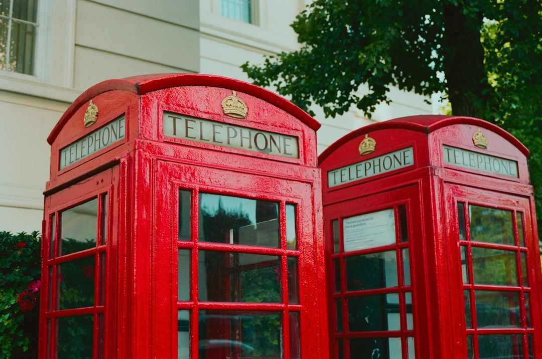 Klassiska röda brittiska telefonkiosker i rad.